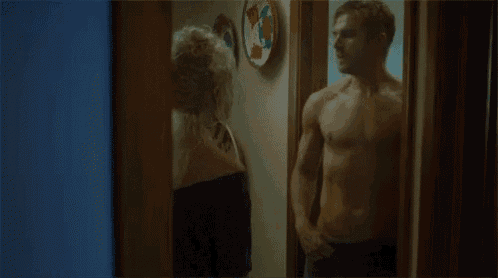 a man without a shirt is standing next to a woman .