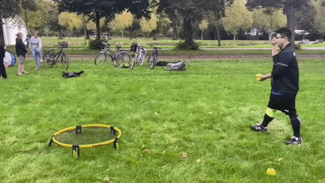 a man is playing a game of frisbee in a park with bikes parked behind him