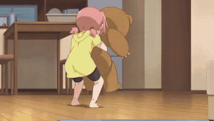 a girl is holding a teddy bear in her arms in a living room .