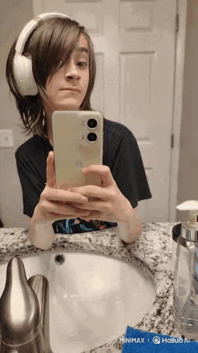 a person wearing headphones is taking a picture of themselves in the mirror