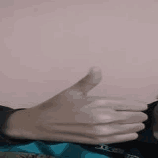 a person wearing white gloves is giving a thumbs up sign .