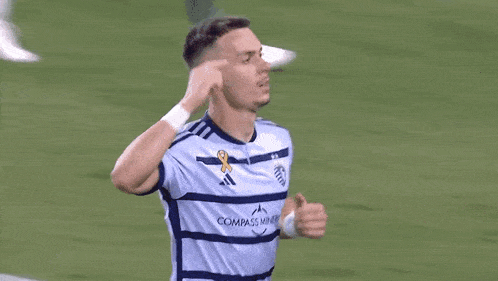 a soccer player wearing a number 26 jersey is raising his arm in the air