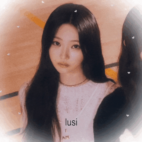 a girl with long black hair is wearing a white shirt that says lusi am