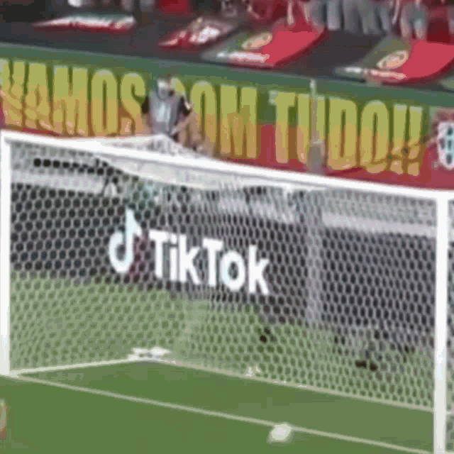 a soccer goal with a banner that says vamos com tudo