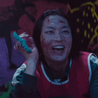 a woman with blood on her face is laughing while holding a toothbrush .