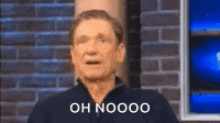 a man is standing in front of a brick wall and making a funny face and saying oh nooo .