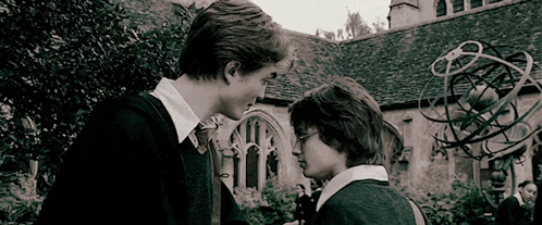 a black and white photo of two boys looking at each other