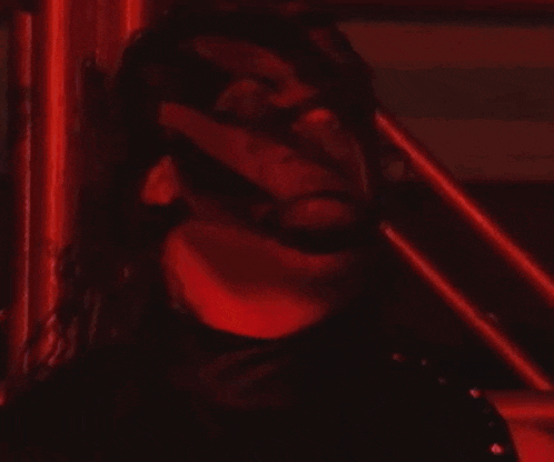a man with a red mask on his face looks at the camera