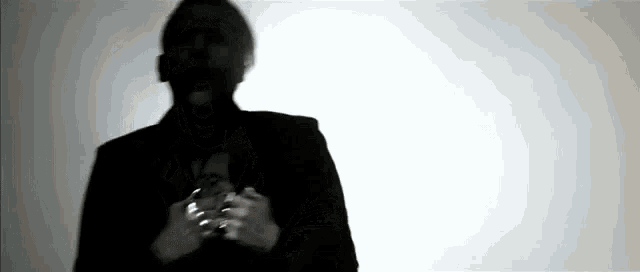 a silhouette of a man in a black suit holding a glass