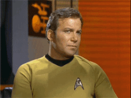 a man wearing a yellow shirt with a star trek logo on the front