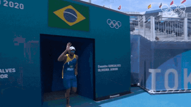 a man in a blue shirt with the word brasil on it walks out of a building