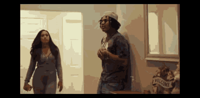 a man and a woman are standing next to each other in a hallway .