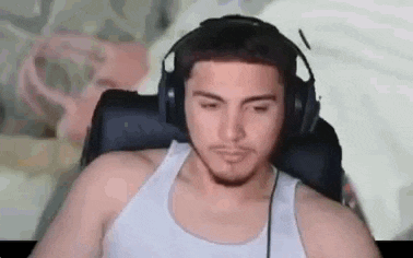 a man wearing headphones is sitting in a chair and looking at the camera .