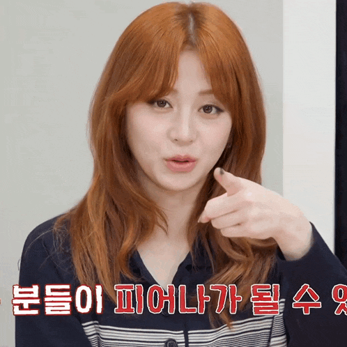 a woman with red hair is pointing her finger at the camera with a caption in korean