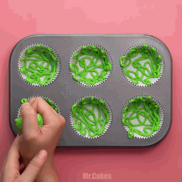 six cupcakes in a pan with green frosting on them