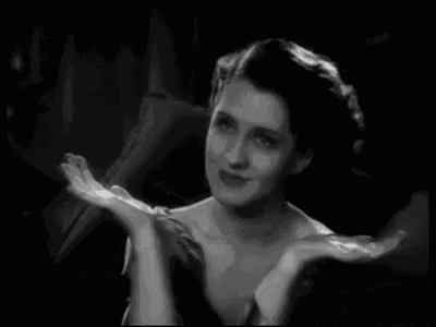 a black and white photo of a woman in a satin dress .