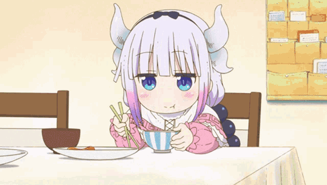 a little girl with horns is sitting at a table eating food