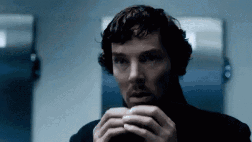 a man in a black turtleneck is holding something in his hands in front of a mirror .