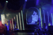a blurry picture of a person playing a keyboard on a stage with purple lights .