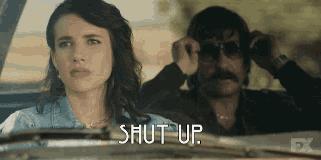 a man and a woman are sitting in a car and the woman is asking the man to shut up