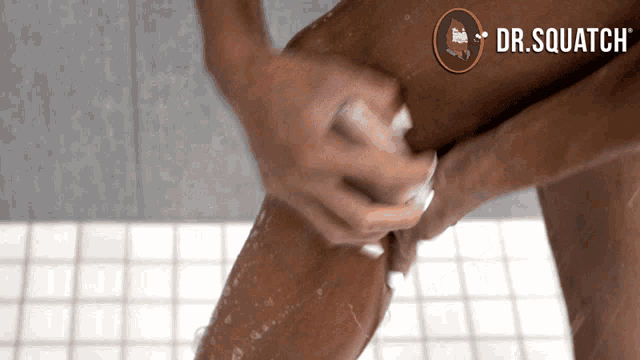 a woman is taking a shower with a dr. squatch logo on the bottom