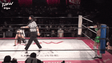 a woman in a wrestling ring with the word universe on the mat
