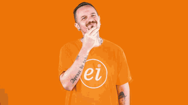 a man with a tattoo on his arm covers his face with his hand