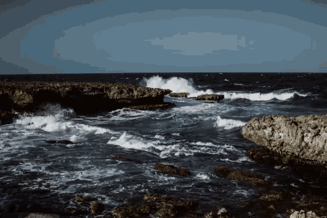 waves crashing on a rocky shoreline on a sunny day