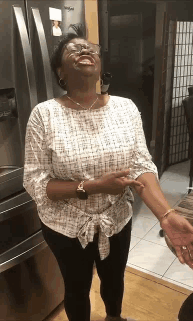 a woman stands in front of a whirlpool fridge