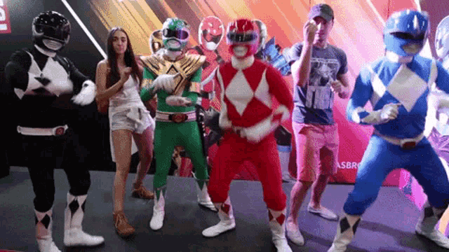 a group of people dressed as power rangers are dancing together
