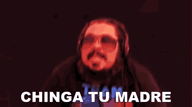 a man with a beard wearing sunglasses and headphones says " chinga tu madre "