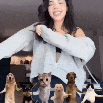 a woman is surrounded by a bunch of animals including a cat and a dog