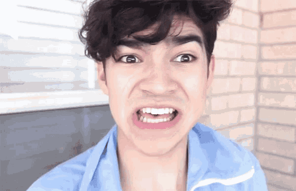 a young man is making a funny face with his mouth open