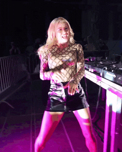 a woman in a gucci shirt is dancing in front of a mixer
