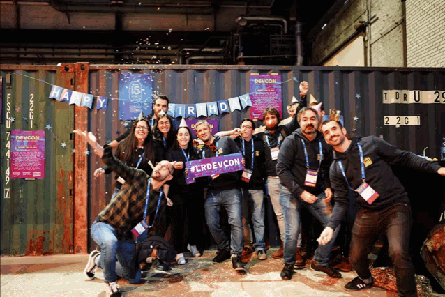 a group of people are posing for a picture with a banner that says happy birthday