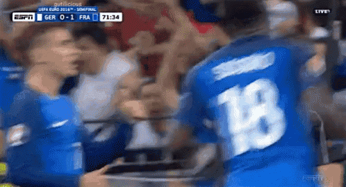 a soccer player wearing a number 18 jersey stands in front of a crowd