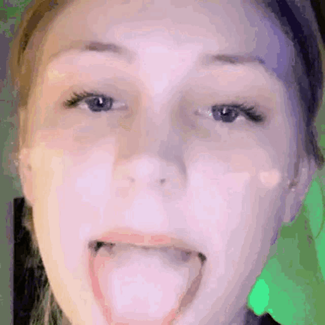 a close up of a woman 's face with her tongue hanging out