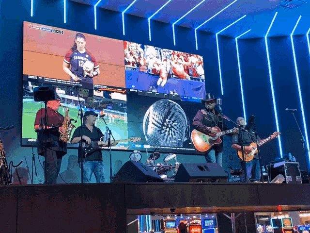 a group of men are playing instruments in front of a large screen that says espn