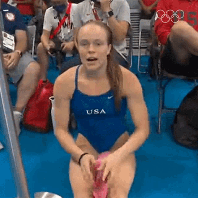 a woman in a blue usa swimsuit is sitting on a chair