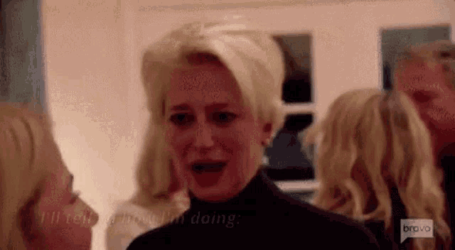 a woman is crying while standing next to a group of women .