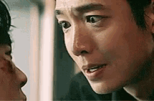 a man is looking at another man 's face .