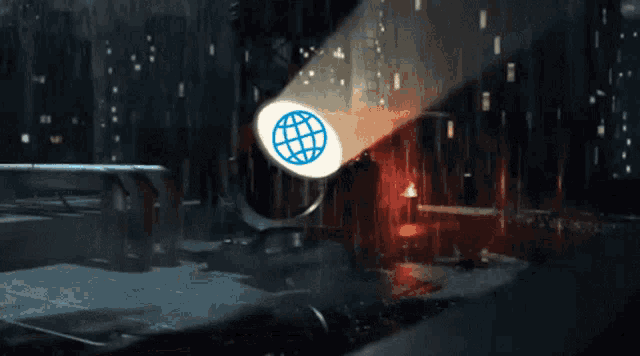 a spotlight shines on a globe in a dark city