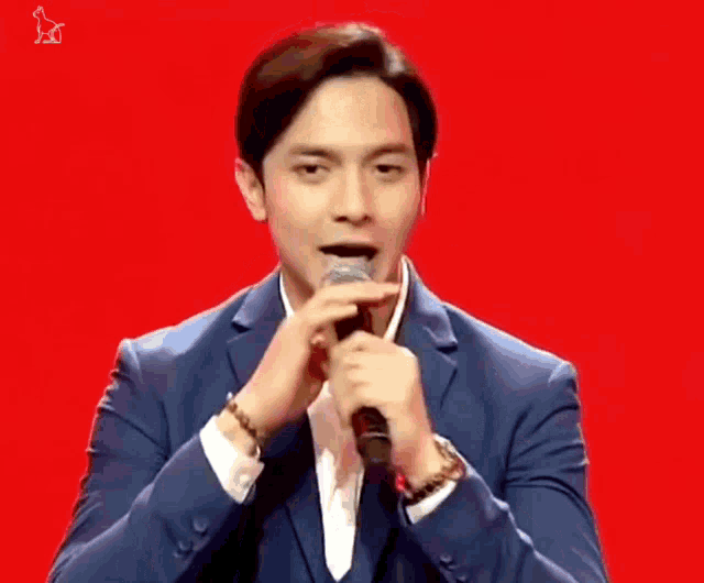 a man in a suit singing into a microphone