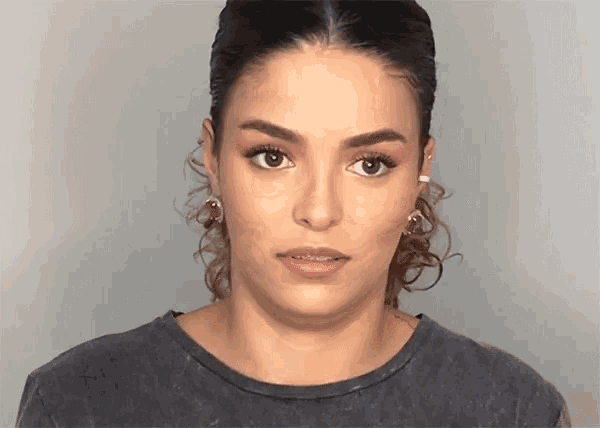 a woman with braces on her teeth is wearing a grey shirt