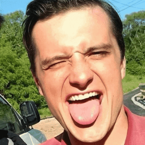 a man sticking his tongue out and smiling