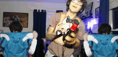 a person holding a video game controller in front of a sign that says ' tn ' on it