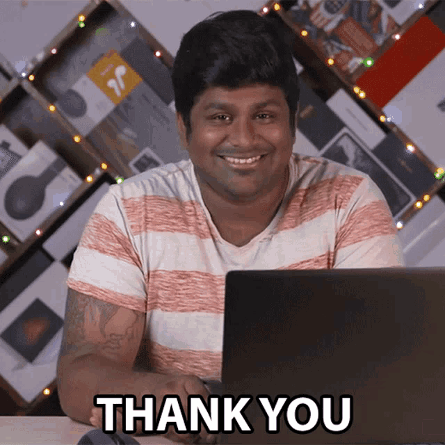 a man sitting in front of a laptop with the words thank you behind him