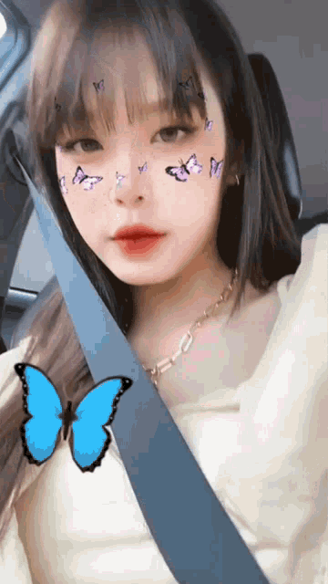 a girl with butterflies on her face is wearing a seatbelt