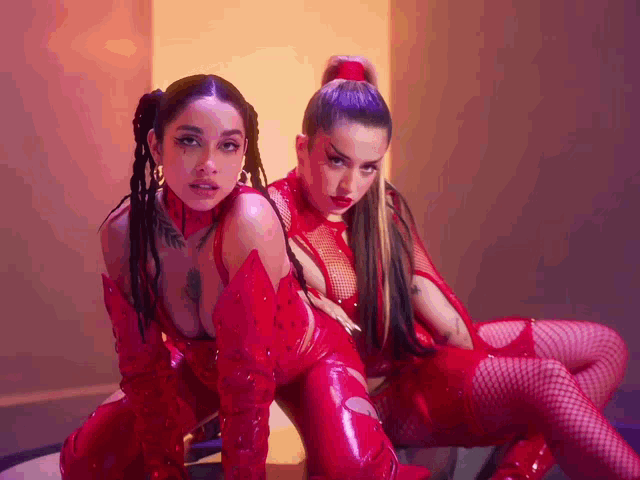 two women are posing for a picture in red outfits