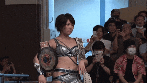 a woman in a wrestling outfit holds a belt that says world heavyweight